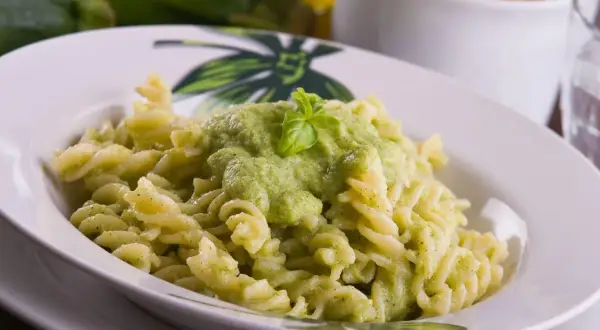 Pyszny makaron fusilli z kremowym sosem z cukinii, udekorowany listkiem bazylii. Idealny na szybki obiad.