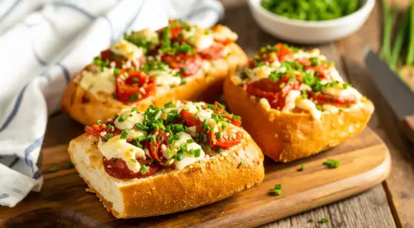 Pyszne zapiekanki z airfryer z serem, pomidorkami i szczypiorkiem na chrupiącej bagietce.