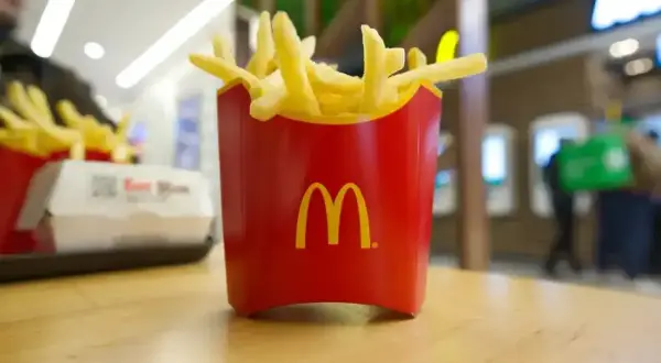 Złociste frytki McDonald's w czerwonym opakowaniu, idealne na szybką przekąskę. Zastanawiasz się nad frytki mcdonald kcal?