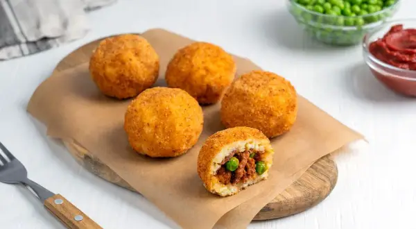 Arancini co to? Złociste kulki ryżowe z mięsem i groszkiem, chrupiące na zewnątrz, pyszne w środku.