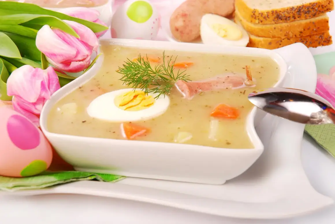 Biały barszcz przepis babci, z jajkiem i kiełbasą, ozdobiony koperkiem. W tle pisanki i tulipany.