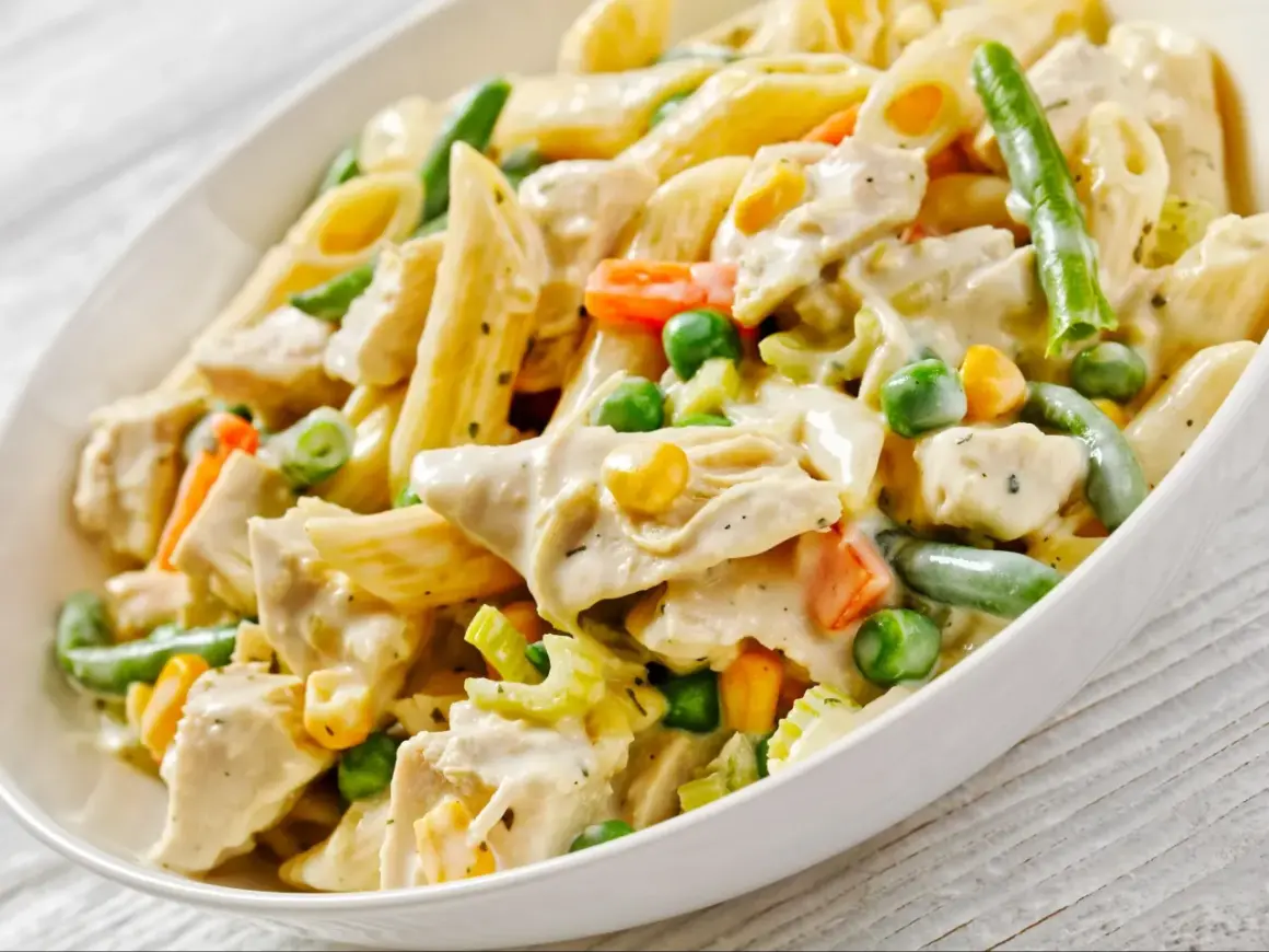 Penne z kurczakiem i kremowym sosem, wzbogacone o zieloną fasolkę, groszek i marchewkę. Pyszny makaron z warzywami.