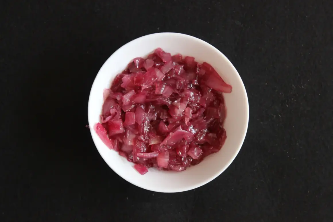 Chutney z czerwonej cebuli w białej miseczce, gotowy do podania.
