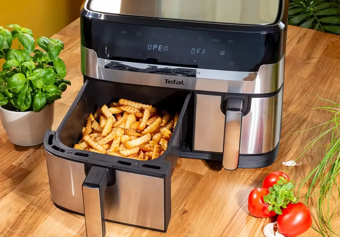 Frytki z frytkownicy beztłuszczowej Tefal, idealne do rankingu air fryer. Obok bazylia i pomidory.