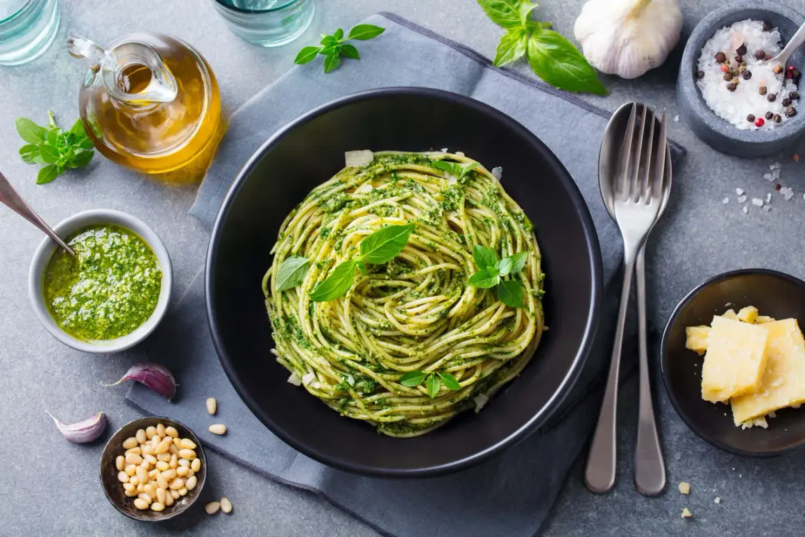 Pyszny obiad bez mięsa: spaghetti z pesto, świeżą bazylią, orzeszkami pinii i parmezanem.