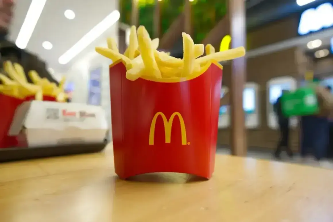 Złociste frytki McDonald's w czerwonym opakowaniu, idealne na szybką przekąskę. Zastanawiasz się nad frytki mcdonald kcal?