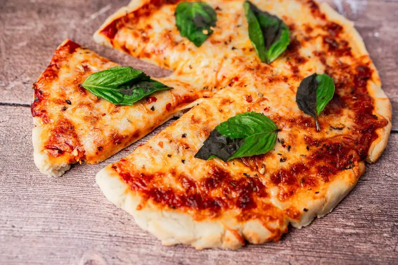 Pyszna pizza z air fryera, z ciągnącym się serem i świeżą bazylią, gotowa do podania.