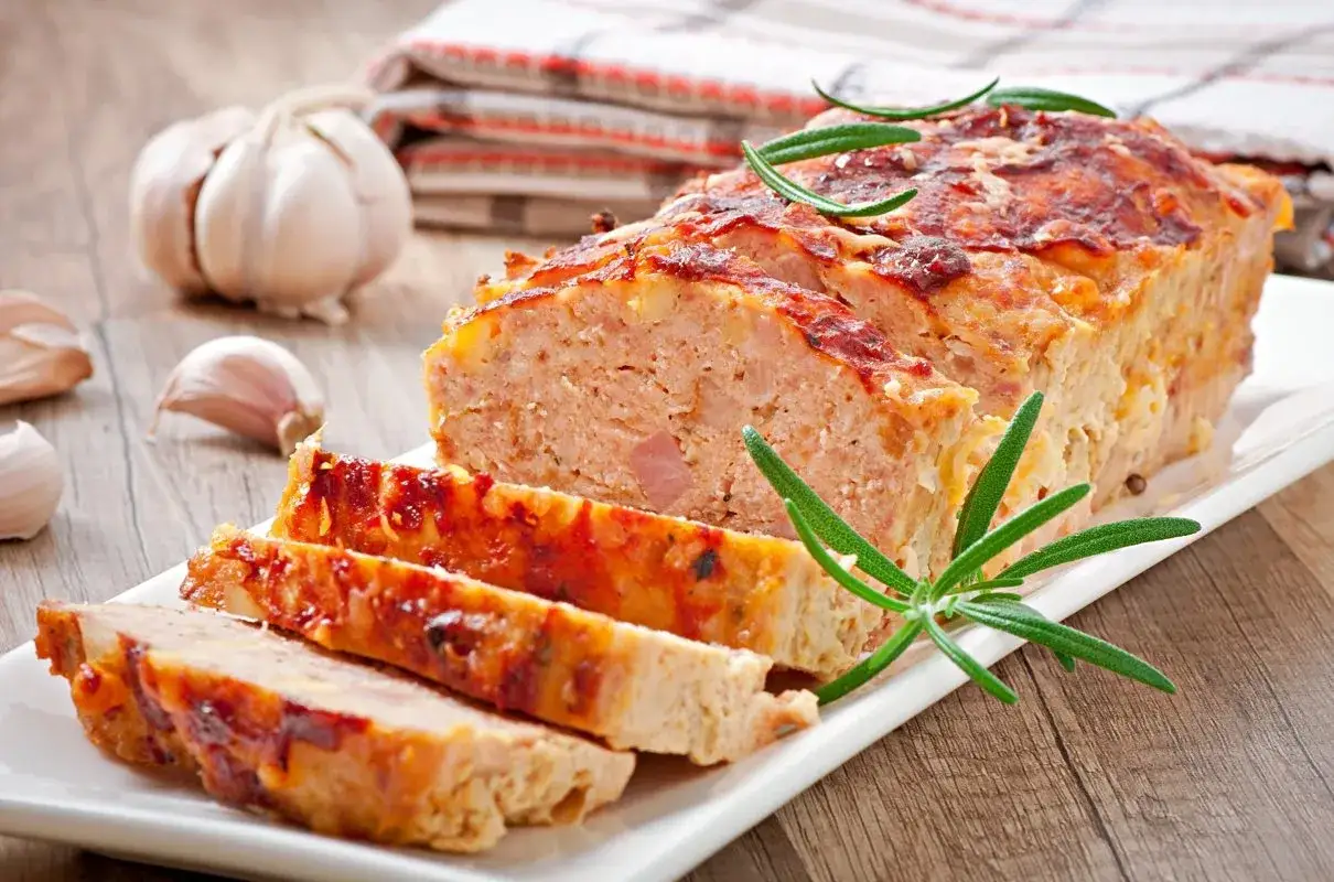 Tradycyjny klops, pokrojony na plastry, z czosnkiem i rozmarynem. Idealny przepis na obiad.