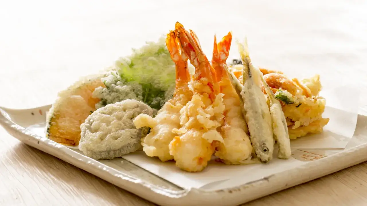 Talerz pełen chrupiącego tempura: krewetki, rybki i warzywa w cieście. Pyszne tempura co to? To japońska uczta!