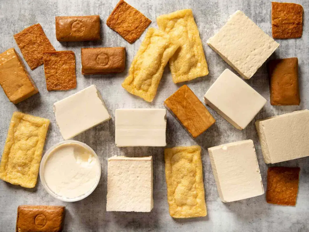 Różne rodzaje tofu, od jasnych kostek po smażone na złoto, pokazują, jak smakuje tofu – delikatnie, lekko orzechowo, a czasem chrupiąco.