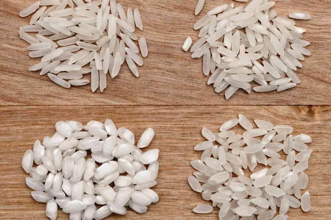 Cztery rodzaje ryżu na drewnianym tle. Dwa górne to długie ziarna, a dwa dolne to krótsze, okrąglejsze ziarna, idealne do risotto.