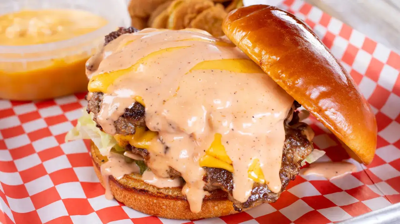 Soczysty burger z podwójną wołowiną, serem i obficie polany sosem tysiąca wysp. Idealny na szybki obiad.