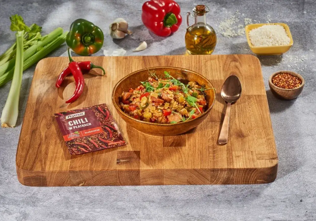 Aksamitna miska z pysznym jambalaya, obok papryka, seler, czosnek, chili i ryż.