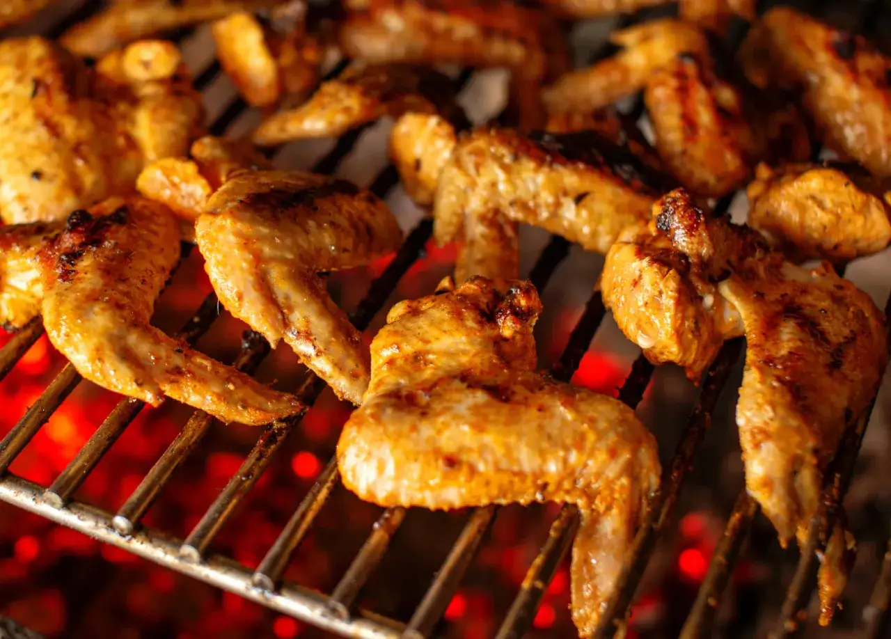 Skrzydełka na grillu, idealnie doprawione marynatą do skrzydełek na grilla, pieką się nad żarem.
