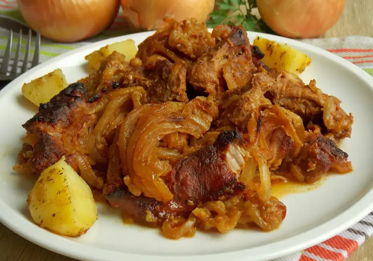 Najlepsza karkówka w cebuli, duszona do miękkości, podana z ziemniakami. Aromatyczne danie, które rozpływa się w ustach.
