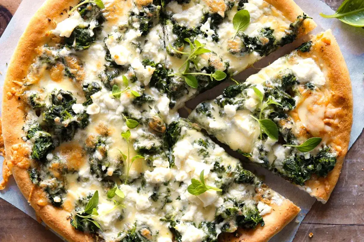 Pyszna pizza ze szpinakiem i białym serem, z chrupiącym ciastem i świeżymi ziołami.