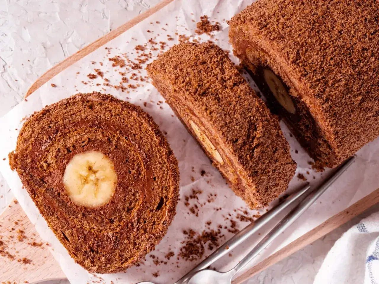 Czekoladowa, najprostsza rolada biszkoptowa z bananem w środku, posypana kakaową posypką.