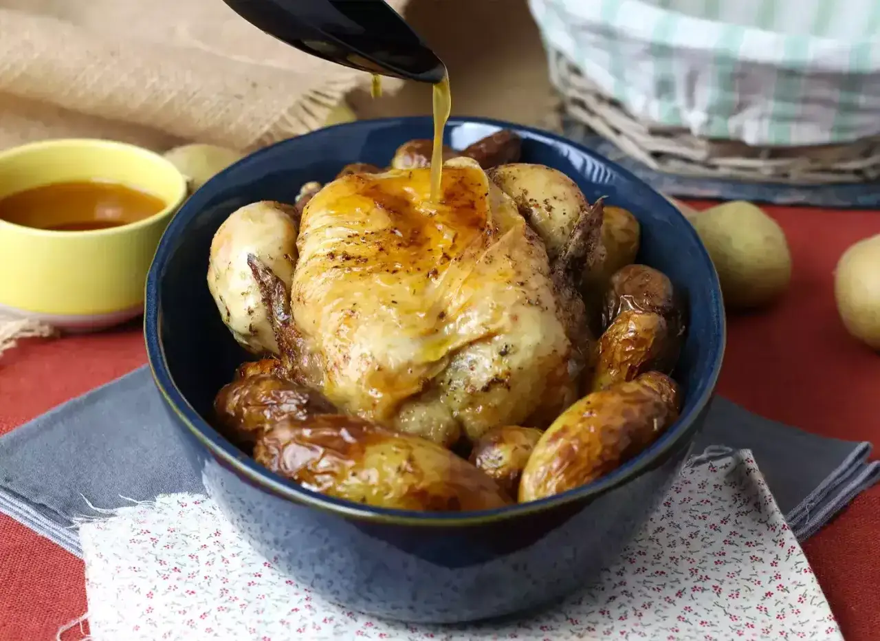 Złocisty kurczak z airfryer otoczony pieczonymi ziemniaczkami, polany sosem. Pyszny obiad gotowy w mgnieniu oka!