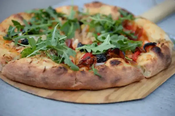 Pyszna pizza z rukolą i oliwkami, idealna na szybki przepis na ciasto do pizzy. Chrupiące ciasto i świeże dodatki zachwycą każdego.