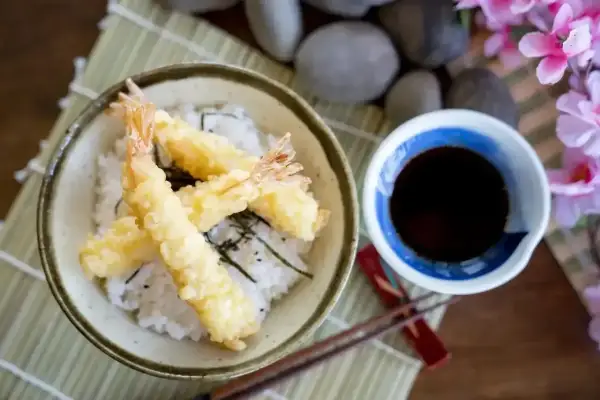 Chrupiące krewetki w cieście, czyli tempura, podane z ryżem i sosem.