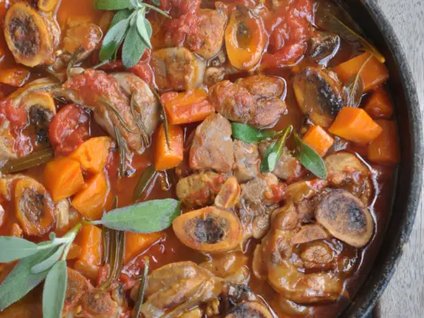 Pyszne ossobuco wołowe w sosie pomidorowym z marchewką i ziołami.