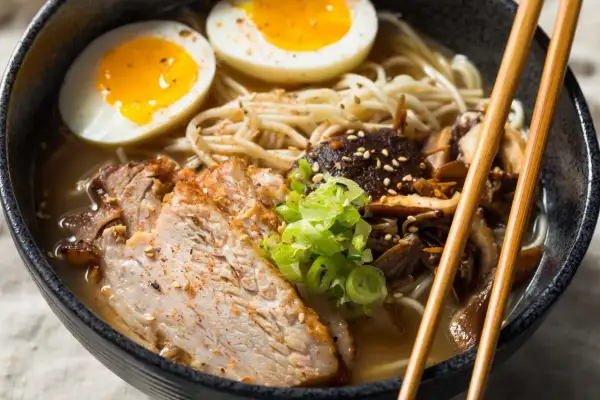 Pyszne ramen z plastrami wieprzowiny, jajkiem na pół i grzybami. Idealne, by dowiedzieć się, jak zrobić ramen.