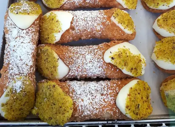 Pyszne, chrupiące rurki z kremem i pistacjami. Idealny dobry przepis na ciasto na rurki, posypane cukrem pudrem.
